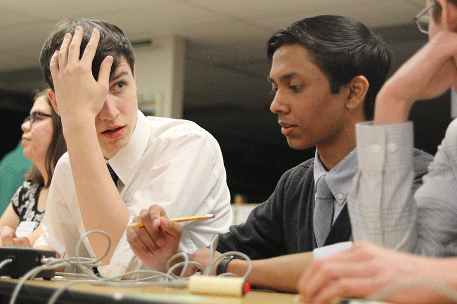 During the Quiz Bowl state competition at Bishop Carroll high school on Saturday, Feb. 14, senior Jack Earlenbaugh discusses the answer to a question with his teammates. 