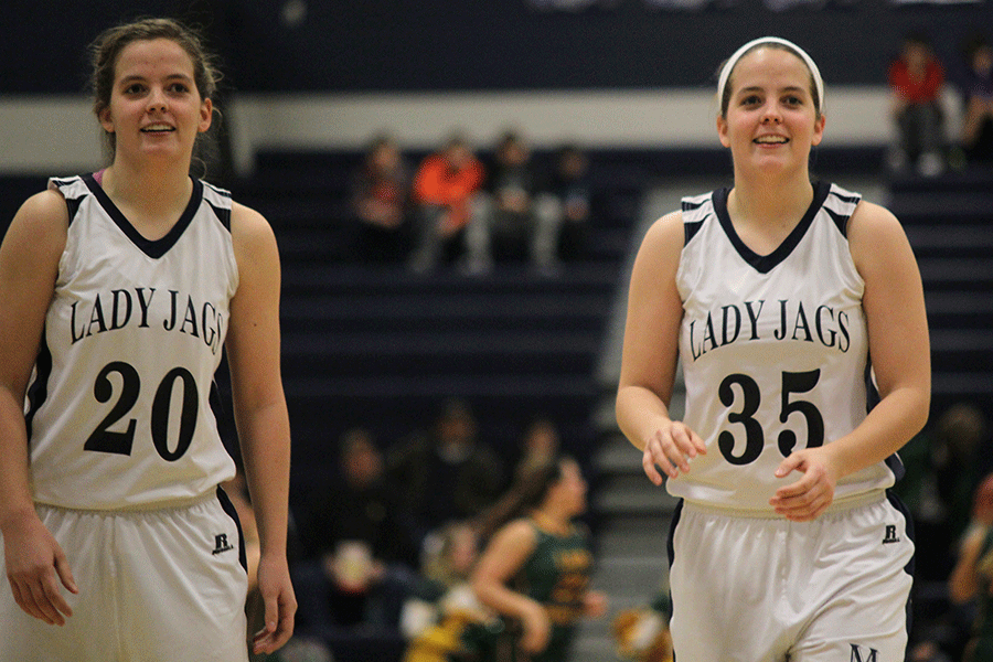 During halftime, seniors Lexie and Lacie Myers warmup by shooting the ball on Friday, Feb. 27.