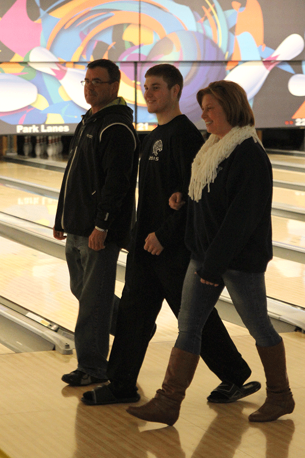 Senior Cole Gray walks with  his parents.