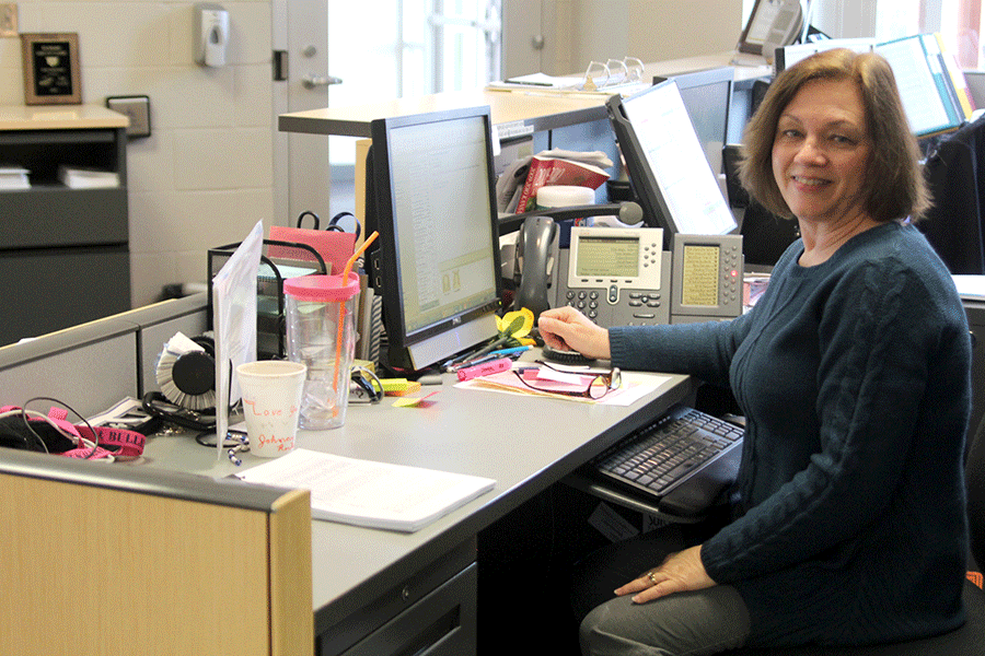 Receptionist Edie Waye sits at her desk in the Main Office on Monday, Feb. 9. I do like being around people, Waye said. I like the excitement. I like changes and the days go by fast.