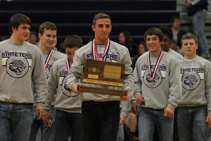 Senior Bryan Burnett holds the third place trophy at halftime of the boys basketball game on Thursday, March. 5.