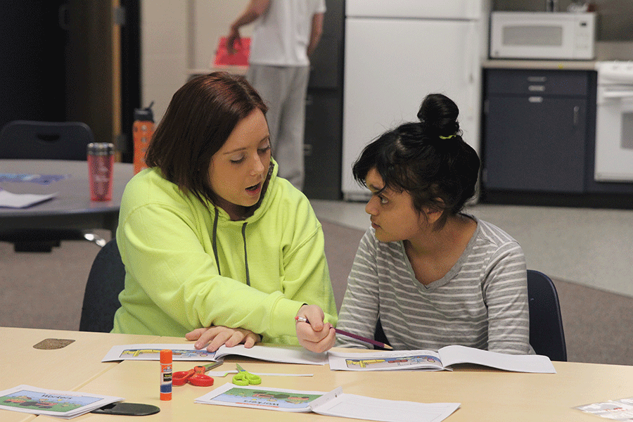 While in the special education room, senior Ashton Ward helps freshman Estefania Mayorga with her schoolwork on Wednesday, Feb. 25. I absolutely love the fact that Im helping other peers with things they might not be able to do the same way others can, Ward said. Its a fun experience all around.
