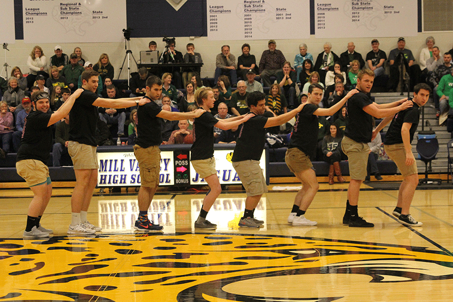 Hands on backs of each other, the senior Silver Studs walk sideways.