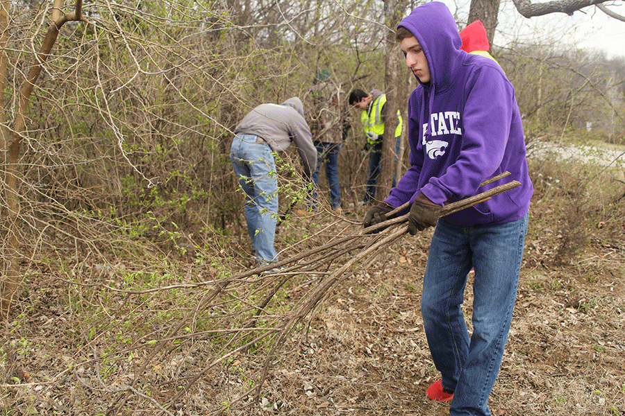 Senior+Drew+Nelson+drags+honeysuckle+branches+after+cutting+them+away+from+Monticello+Trails+Park+on+Saturday%2C+March+28.+