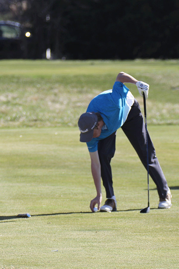 At the golf meet, senior Matthew Bahle places his golf ball.