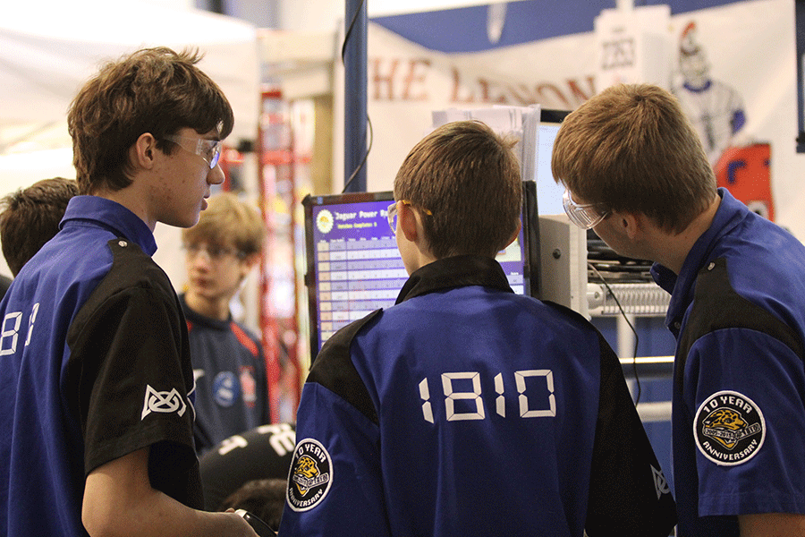 Members of the robotics team look at the scores of their competition.