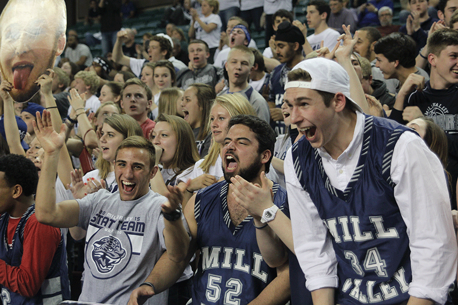 Screaming in excitement, seniors Bryan Burnett, Sebastian Uriarte and Chase Battes support the boys basketball team in the final moments of the quarterfinal game against Maize South.