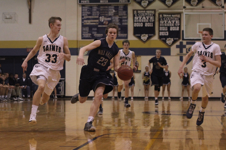 Driving the ball down the court, freshman Cooper Kaifes dribbles towards the basket.