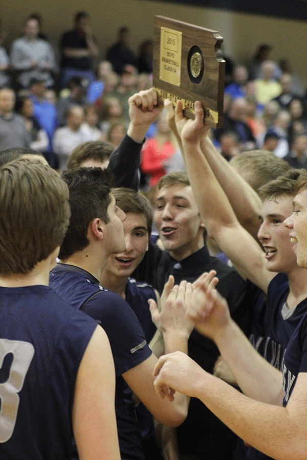 Players hoist their sub-state championship trophy above their heads.