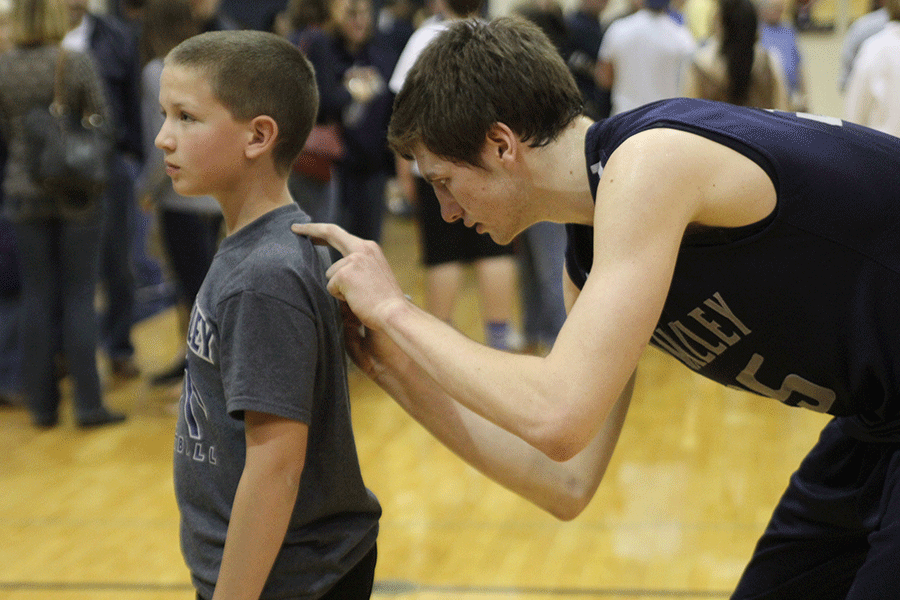 Junior Clayton Holmberg signs a childs shirt after the game. 