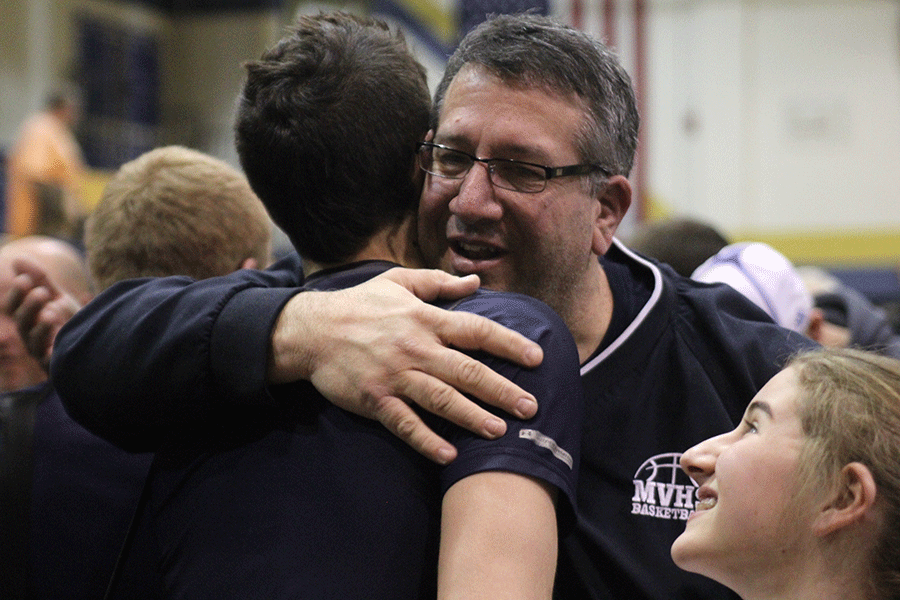 Senior Evan Kopatich is hugged by his father after the win over Aquinas.