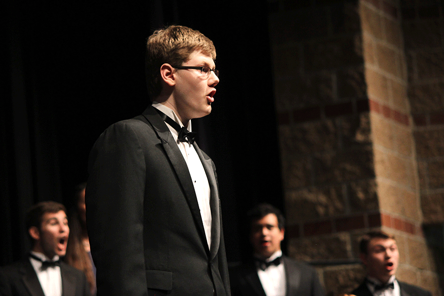 Senior Henry Hanson sings his solo center stage during the choir concert. 