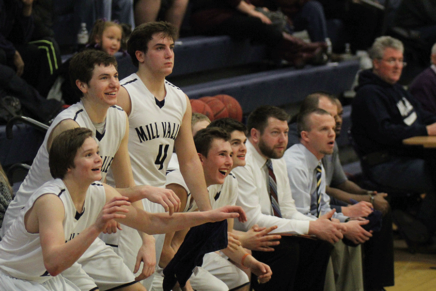 Freshman Cooper Kaifes, and juniors Clayton Holmberg and Logan Koch rise to cheer for a team member. 