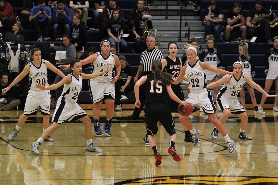 The+girls+basketball+team+holds+a+strong+defense+against+a+player+from+Blue+Valley+West+in+their+substate+match+on+Wednesday%2C+March.+4.+