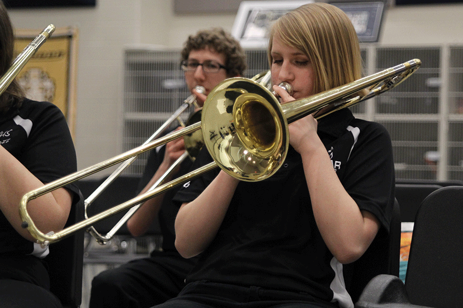 Holding+her+trombone+closely%2C+senior+Kate+Schau+practices+before+the+concert.