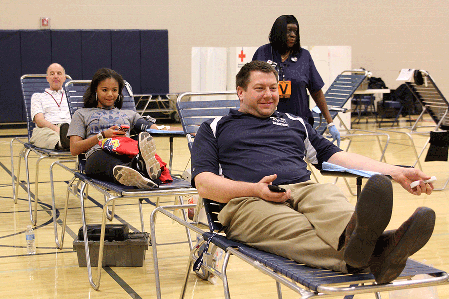 Math teacher Alex Houlton, along with other faculty and students, donates blood to Red Cross in the auxiliary gym on Thursday, March 26.