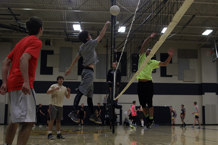 Junior Cooper Hutteger spikes the ball over the net on Wednesday, March 25. [Kick butts day] is very fun. I like the atmosphere, Hutteger said. 