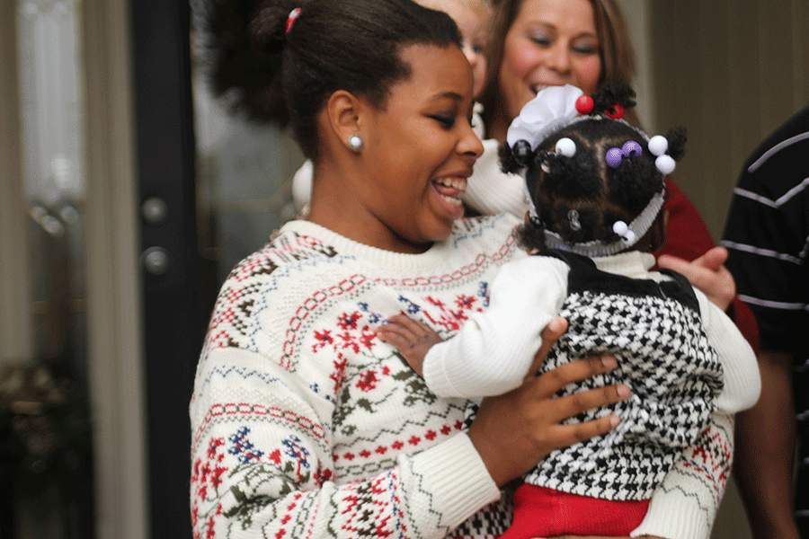 Outside her home on Sunday, Dec. 7, junior Sydney Humphrey smiles holding one of her foster sisters.