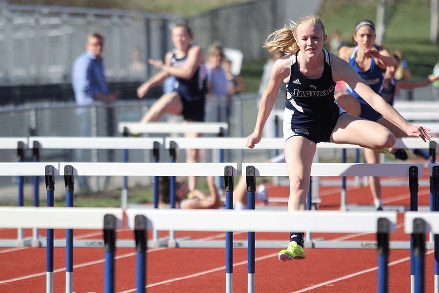 Senior Holly Webb jumps over a hurdle.