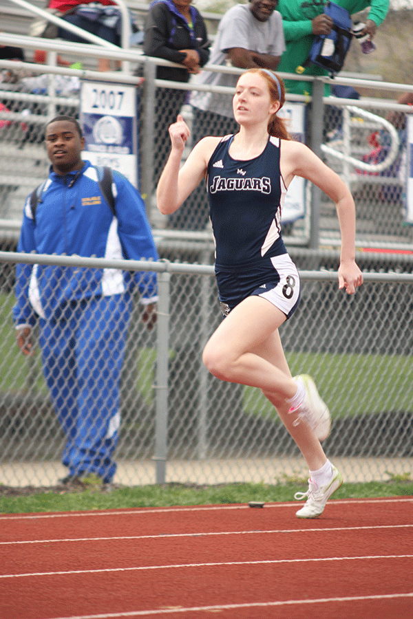 Junior Sally Carey runs in the 100m dash.