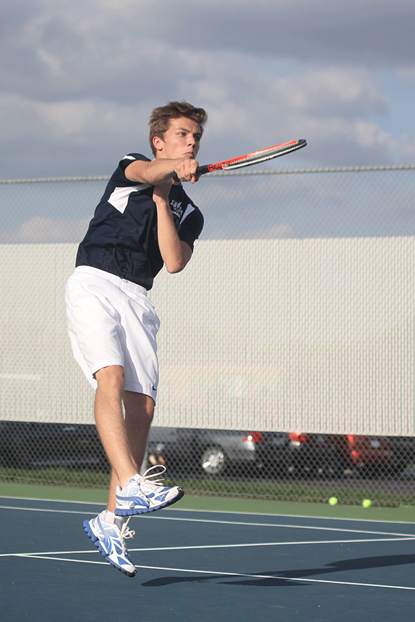 In the air, senior Eric Marquardt hammers the ball across the court.