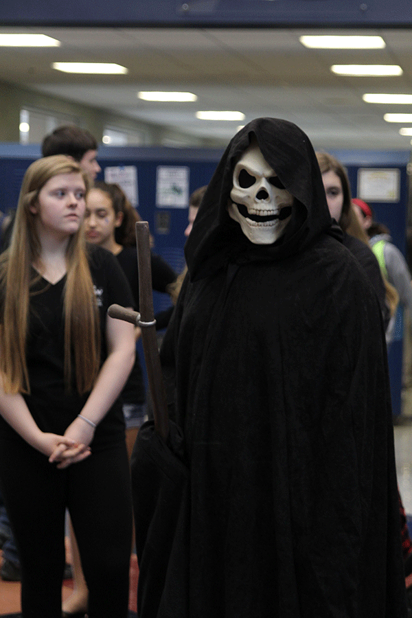 The Grim Reaper stands at the end of the main hall with those who have passed due to distracted driving.