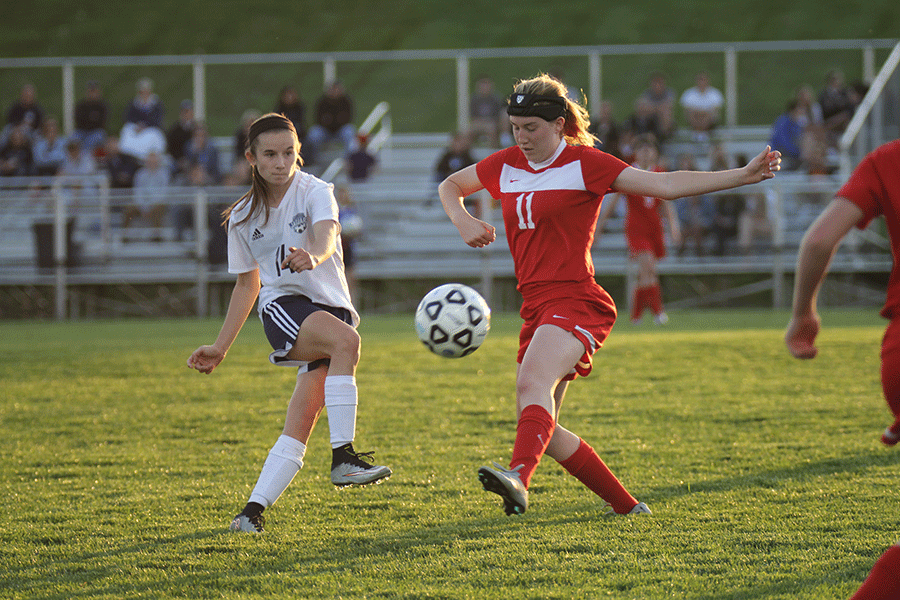 Junior Kennedy Hoffman kicks the ball past a Lansing opponent on Tuesday, April 21. The team fell to Lansing, 1-0.