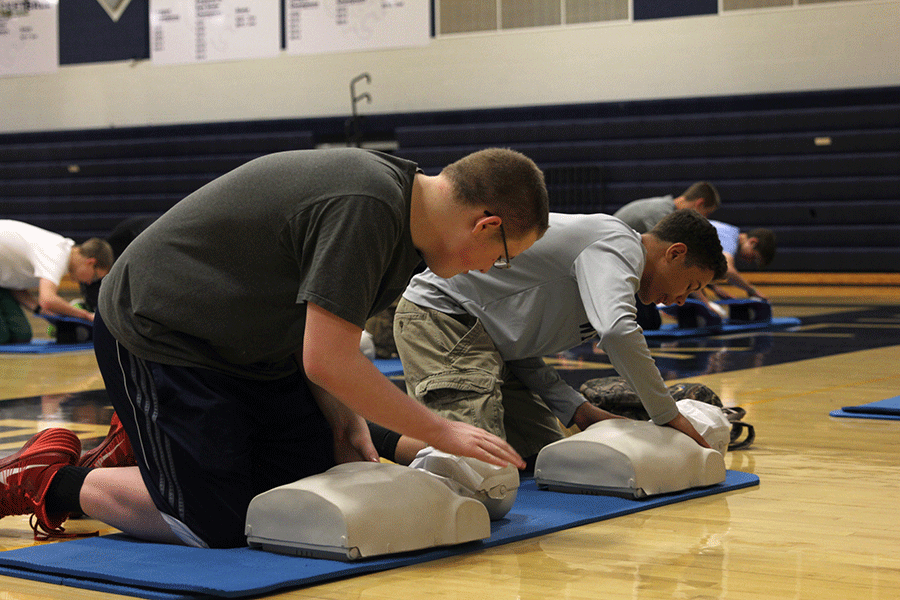 Freshman+Cameron+Mitchell+pats+the+mannequin+to+simulate+the+steps+of+CPR.