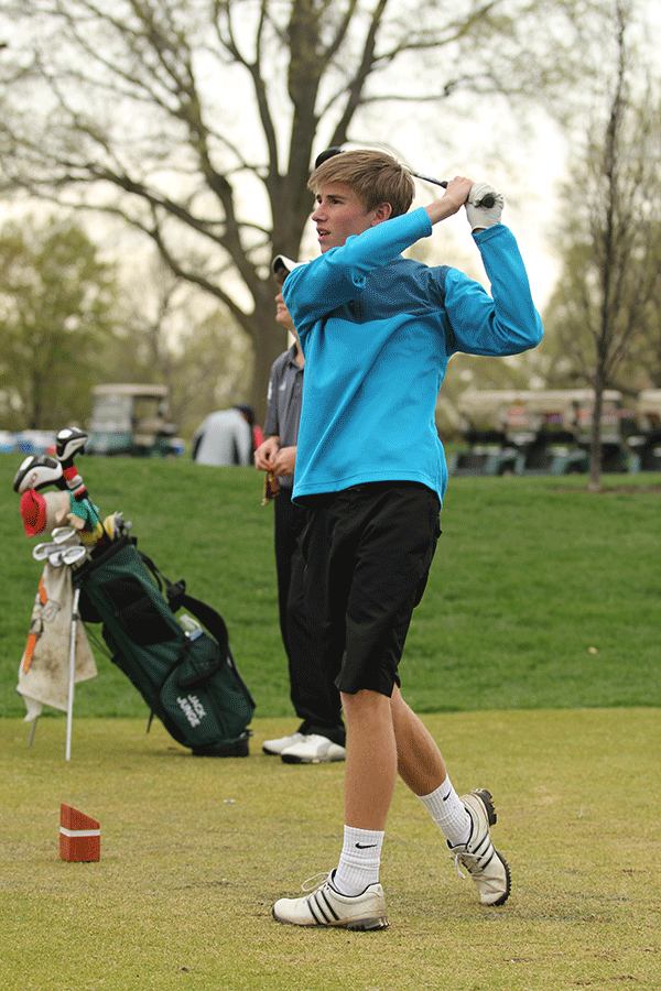 Ball in the air and club in his hand, senior Jack Casburn watches his ball land farther down the course.