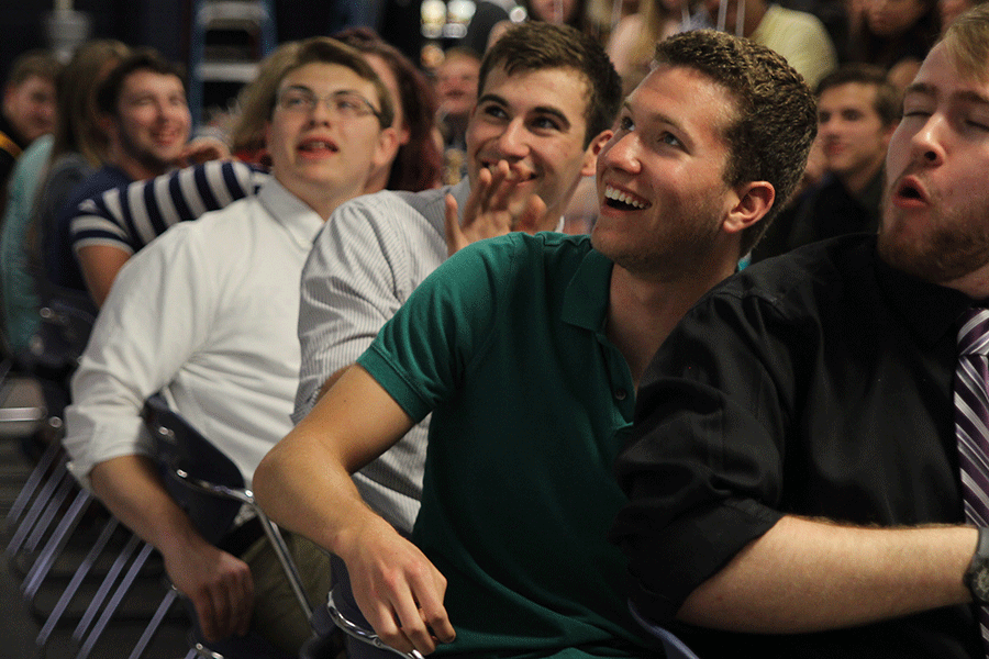 Senior Eli Stewart pats senior Cody Deas on the back as a funny picture of Deas from a previous show appears on the screen.