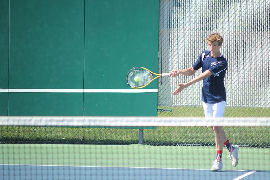 During the tennis dual on Thursday, April 30, sophomore Spencer Butterfield forehands the ball to his St. James Academy opponent. 