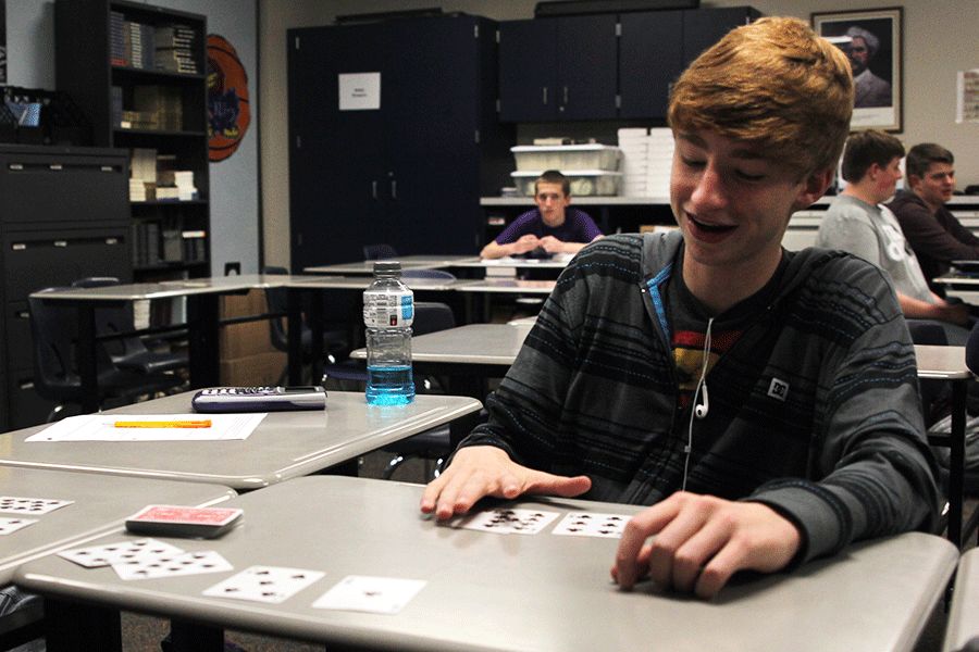 Moving cards around on his desk, freshman Jason Easley preforms a card trick for his classmates on Wednesday, April 15. 