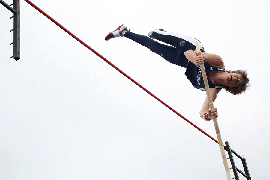 Pushing his pole back, senior Colton Bray pushes himself over the pole vault.