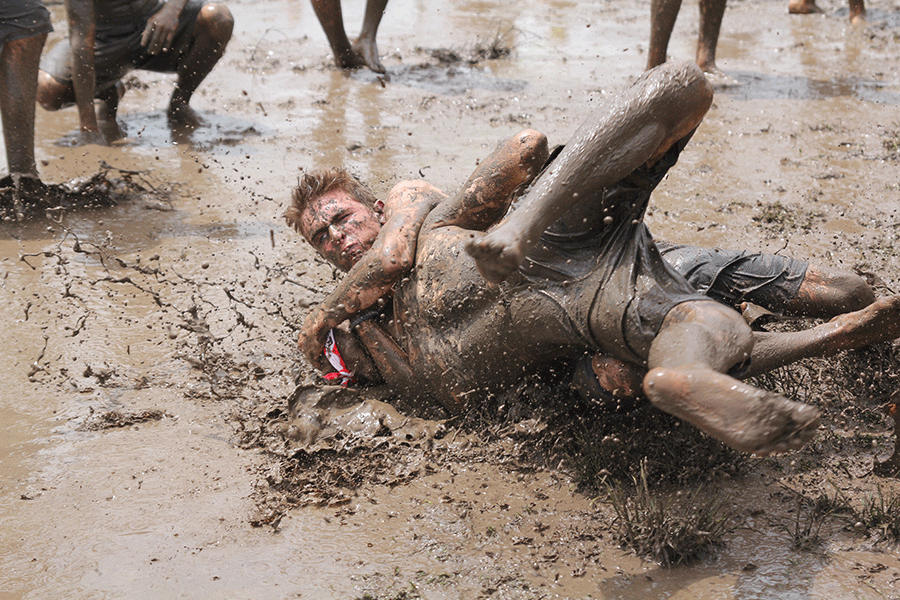 Junior Ethan Lane tackles an opposing team member into the mud.