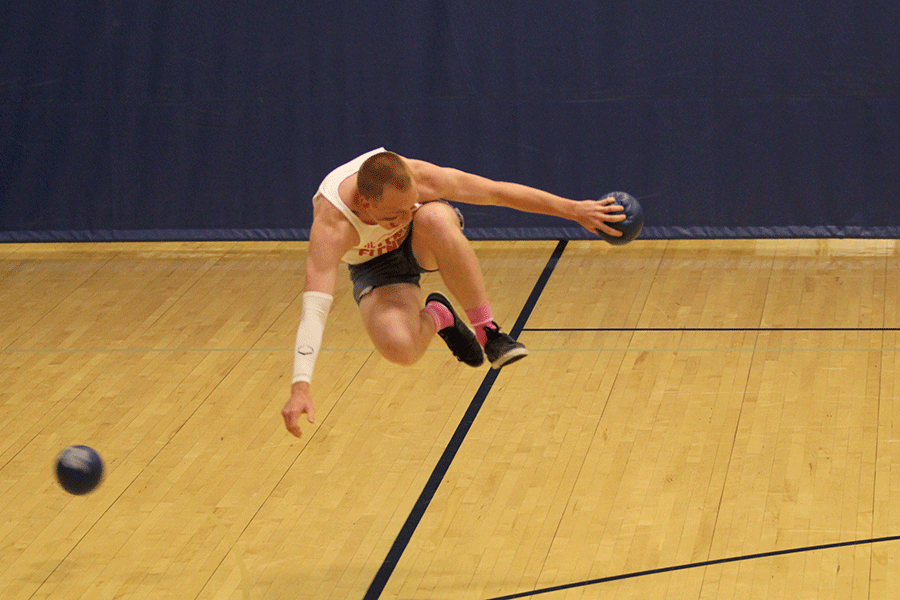 While trying to keep his team in the match, senior Ty Bruce jumps to dodge a ball.