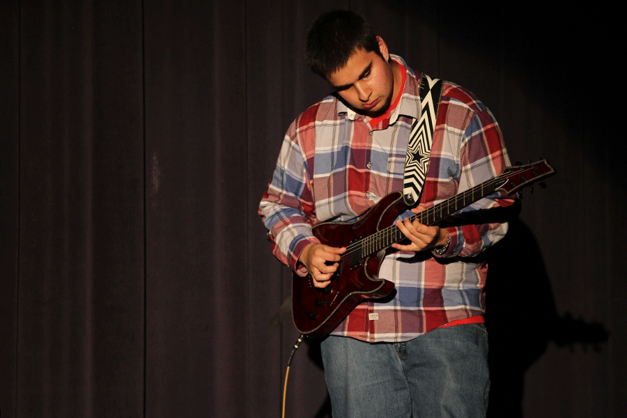 Junior Manuel Abril performs a guitar solo for the talent show attendees. 