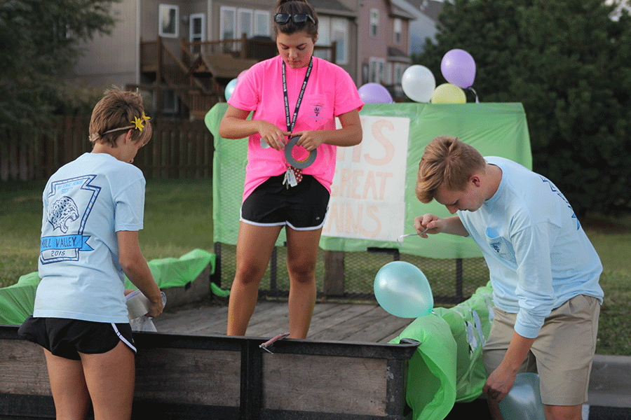 Seniors Shelby Hudson, Erikia Krigen and Junior Brady Rolig decorate the NHS float on Wednesday, Sept. 16.