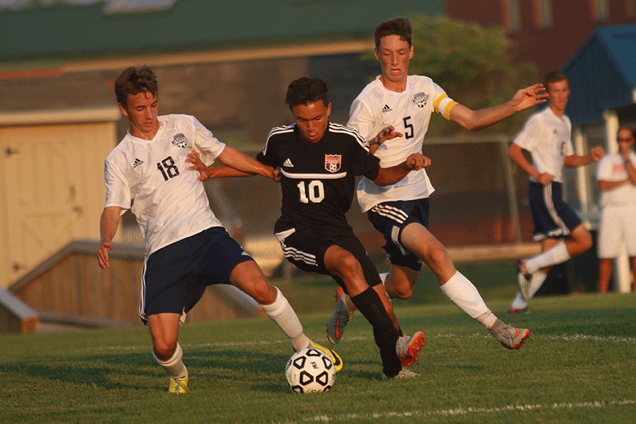 Battling for the ball, juniors Ethan Doyle and Hayden Vomhof take possession from the opposing team.