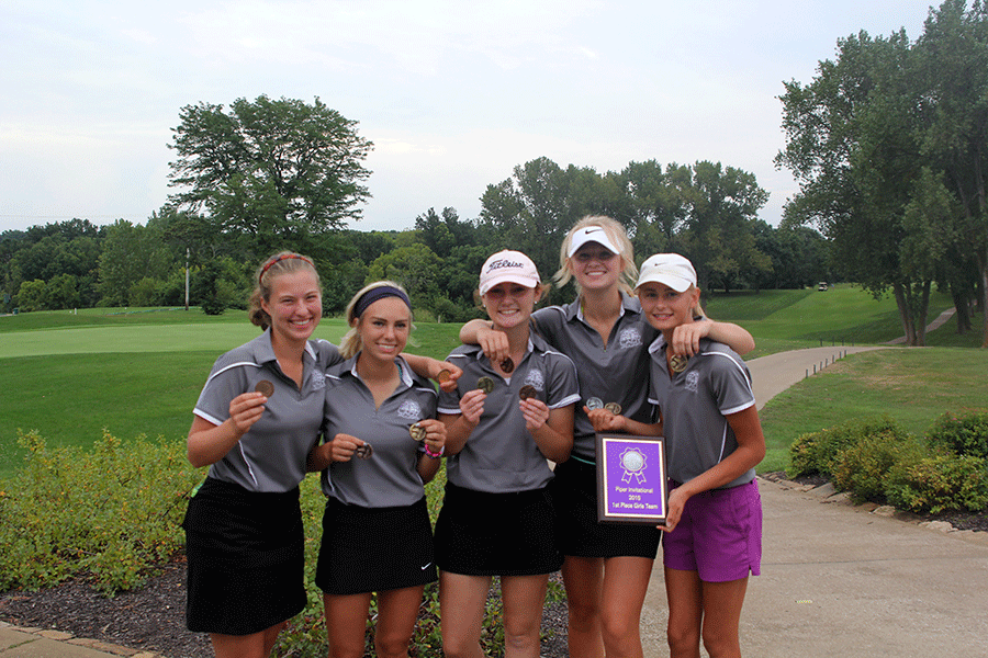 After placing first as a team with a combined total of 366, the girls pose for a picture holding their medals and team plaque.