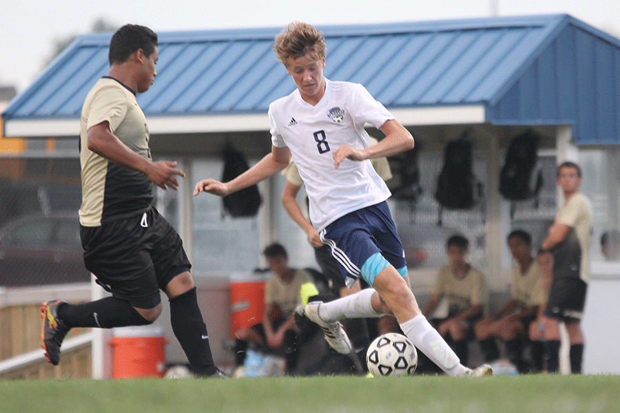 As he is about to pass the ball, junior Spencer Butterfield tries to outrun an opponent on Thursday, Sept. 10. The team won 7-1 against turner.