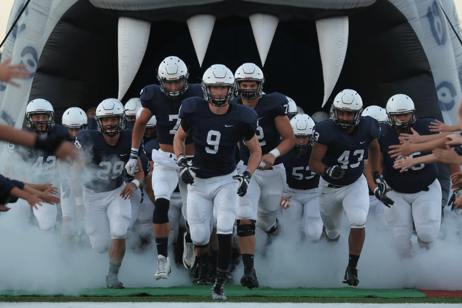 Seniors Cole Morris, Lucas Krull and Ben Hecht lead their teammates out of the tunnel at the football game against KC Southwest on Friday, Sept. 25.