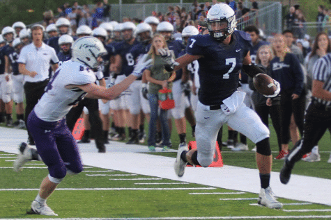 Making a break for the end zone, senior Luke Krull blocks the defender, maintaining the lead against BVNW.