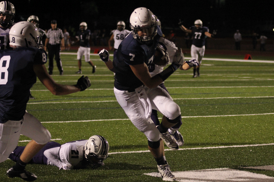 Avoiding a tackle, senior Luke Krull rushes towards the end zone to score a touch down against the Huskies.