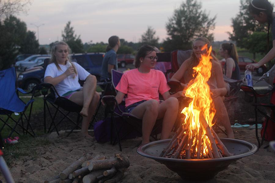 Senior Micaela Crispin and sophomores Nora Lucas and Dani Crispin gather on the Grey Oaks sand volleyball court as part of the Club 121 bonfire on Saturday, Sept. 5. I really enjoyed getting to discuss our interpretations of some Bible verses, and getting to hang out with my friends, Lucas said. 