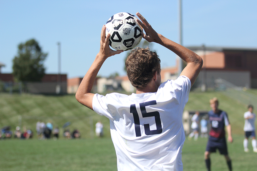 On the sideline, freshman Jake Ashford inbounds the ball against opponent on Saturday, Sept. 26. The team won against Topeka with a score of 2-1.