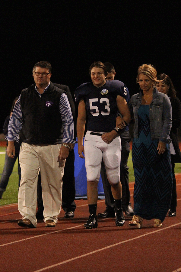 Senior Tyler Shurley is escorted down the track by his parents. 