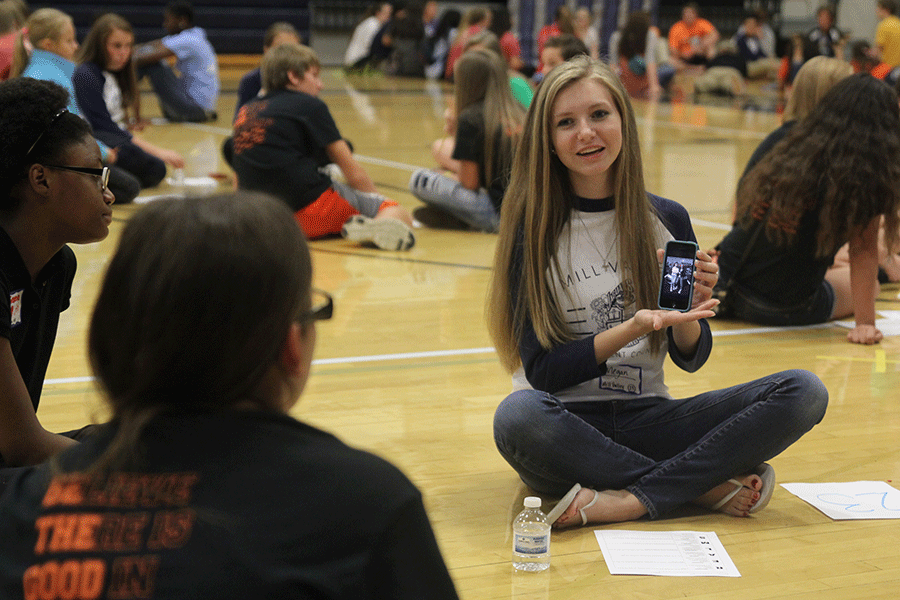 While leading a mini group at the StuCo conference,  senior Megan Feuerborn shows a picture on her phone. 