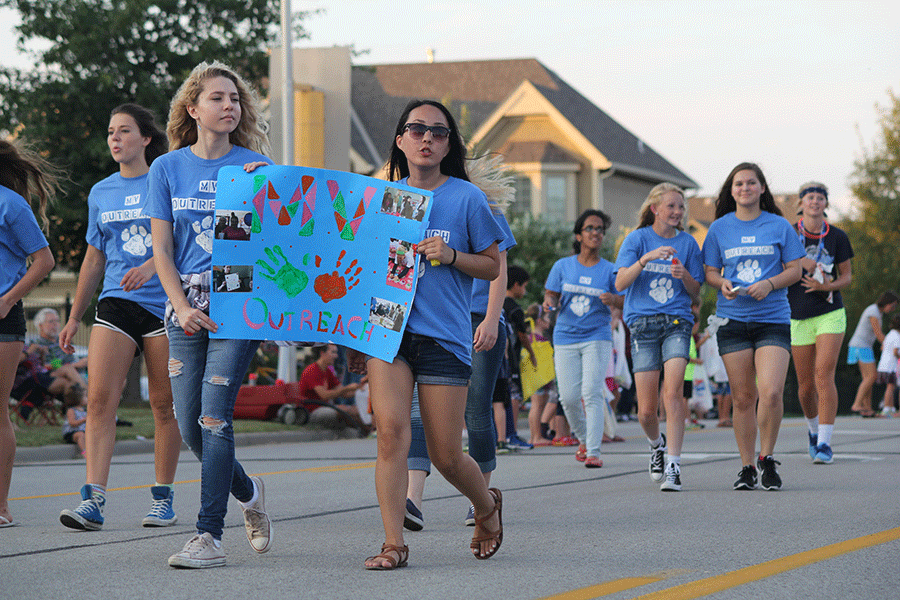 Juniors Emma Wilhoit and Sue Kim lead the MV Outreach float on Wednesday, Sept. 16.