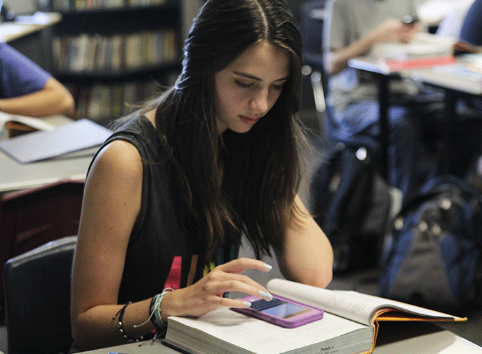 In communication arts teacher Mike Strack’s classroom on Thursday, Sept. 3, senior Lily Sawyer uses her phone to get on Blackboard. After reading a story, she used the discussion board feature to answer a writing prompt.