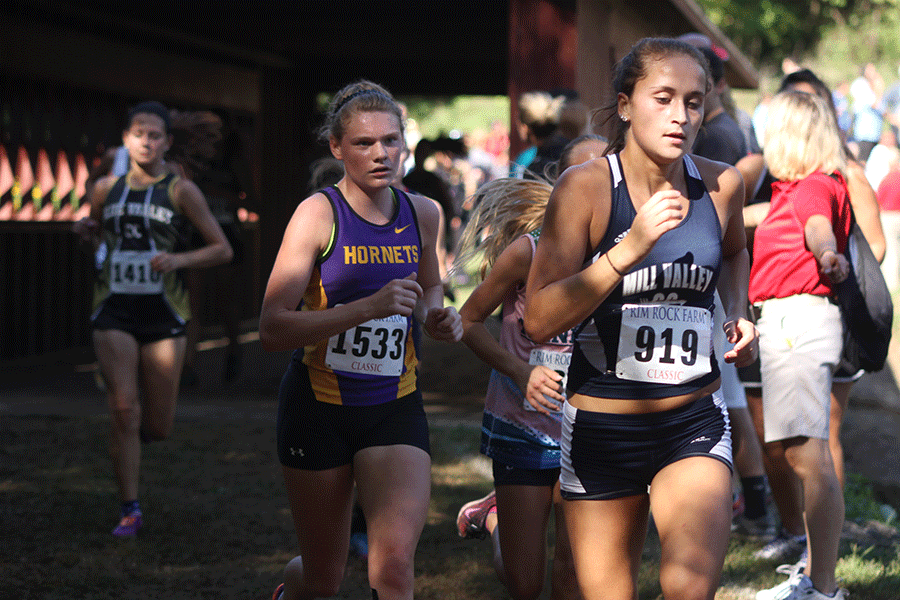 Pumping her arms, junior Anna Clayborn leads a pack of girls during the girls varsity crimson race at Rim Rock Farms on Saturday, September 26. The girls team finished fifth and the boys team took fourth.